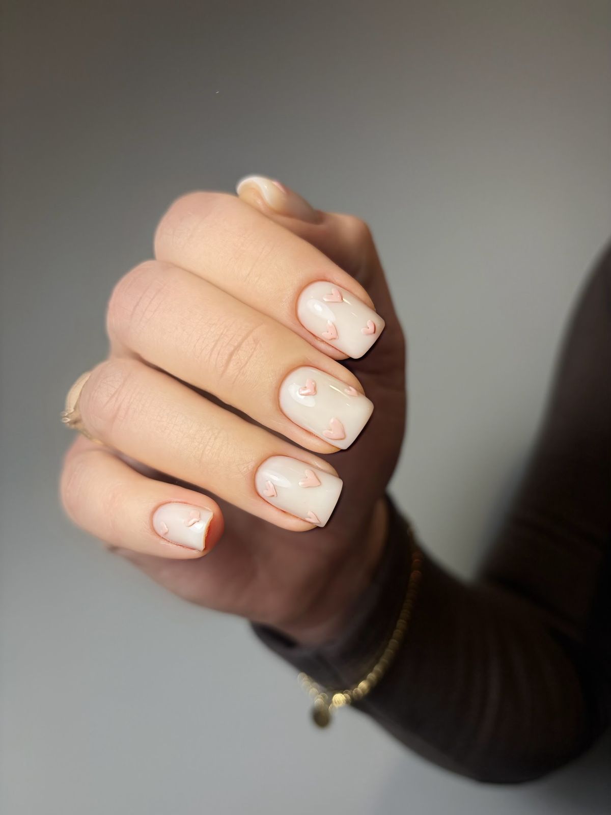 Korte melkwitte nagels met fijne perzikkleurige lijntjes