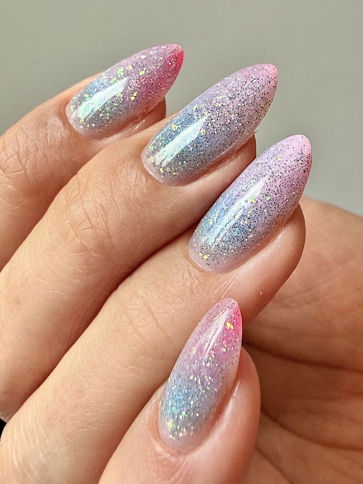 Lange amandelvormige nagels met roze en zilveren glitter ombre
